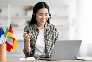 happy-asian-lady-using-laptop-and-headset-learning-foreign-language.jpg